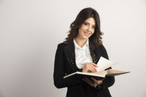 Positive teacher posing with open notebook Positive teacher posing with open notebook